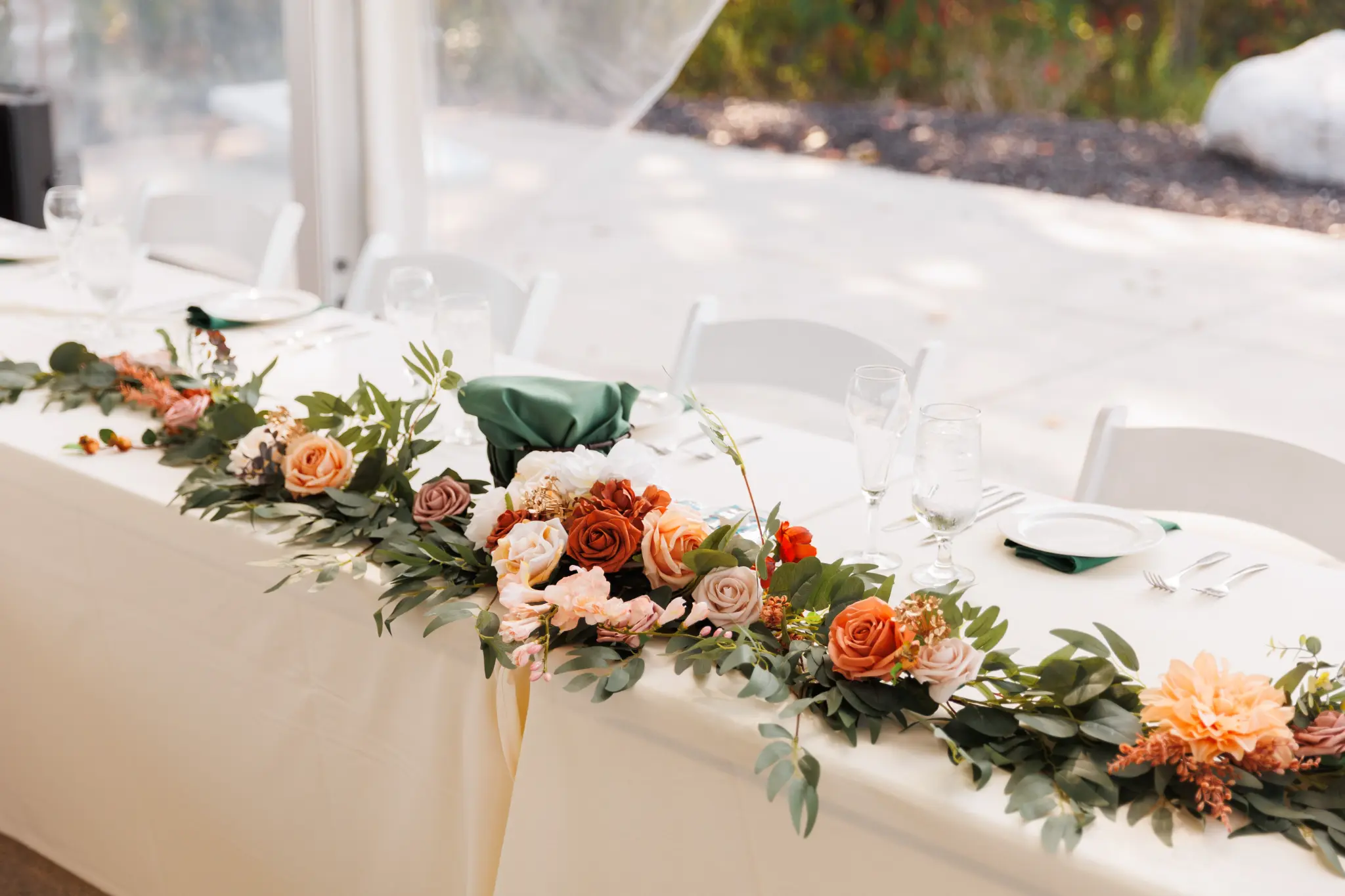 Head table at a fall wedding reception with seasonal decor
